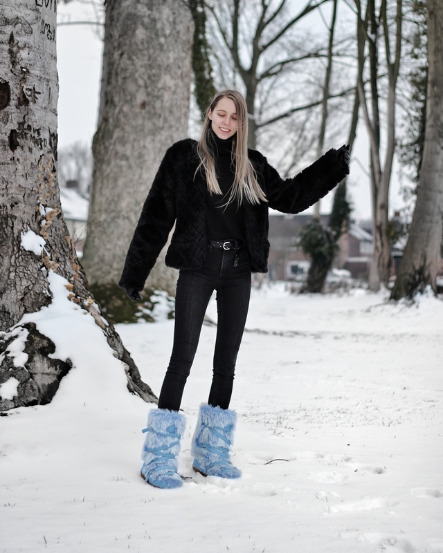 Outfit met blauwe fluffy sneeuwlaarzen snowboots met imitatiebont zwarte winter outfit mode blogger sneeuw inspiratie