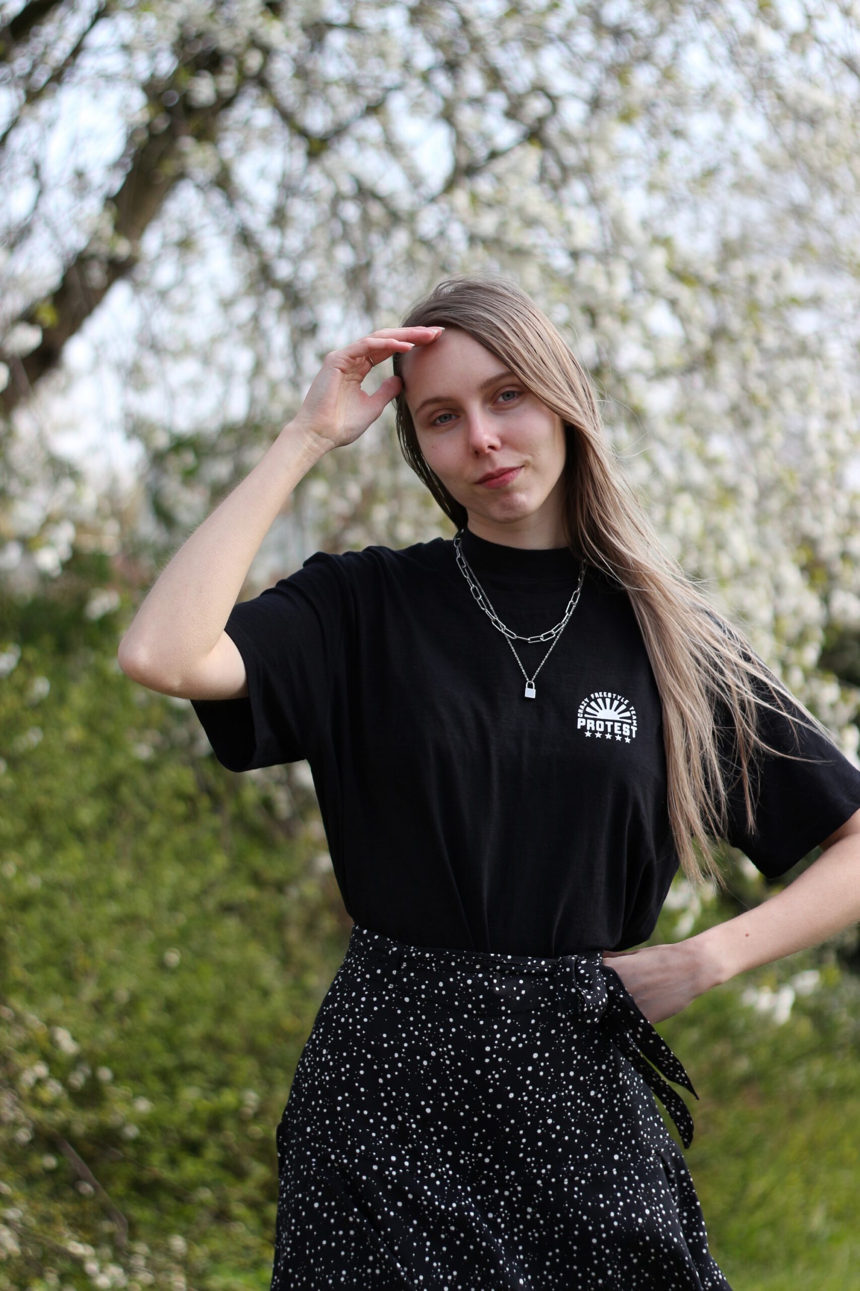 Nederlandse mode blogger zwarte outfit zomer Protest sportswear streetwear broekrokje skort shirt met print op rug Dr Martens Blake II bloesem fotoshoot